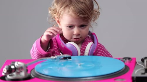 Child Plays with a Pink Record Player