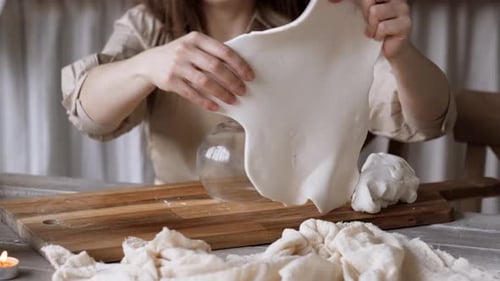 Baker Shaping White Dough Ball on Cutting Board