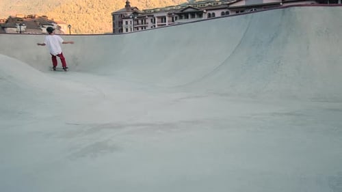 Skillful Skateboarder Practicing in Skatepark with Bowl Ramp