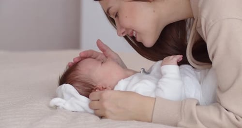 Smiling Mother bonding with Infant at Home