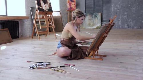 Professional Artist Draws Picture Sitting on the Floor Her Workshop