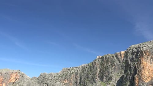 Castle On The Mountain Summit With High Cliff Rocky Wall