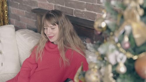 Woman Relaxing Near Christmas Tree Indoors