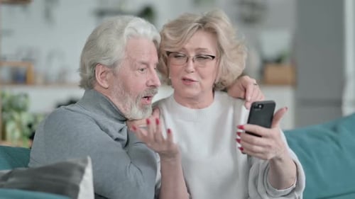 Mature Couple Using Smartphone Together at Home