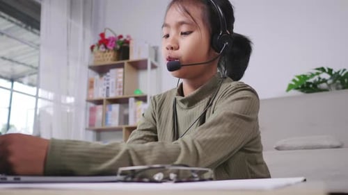 Girl Studies Online with Headset and Laptop