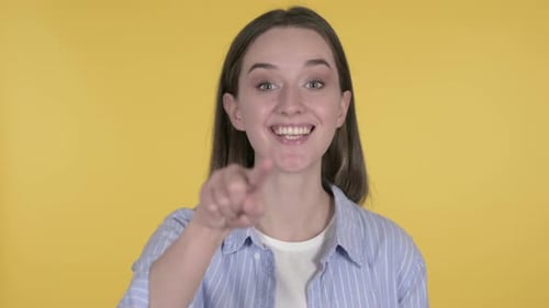 Smiling Woman Waving on Yellow Background