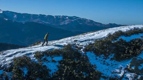 Hiker Walking on Snowy Mountain Ridge