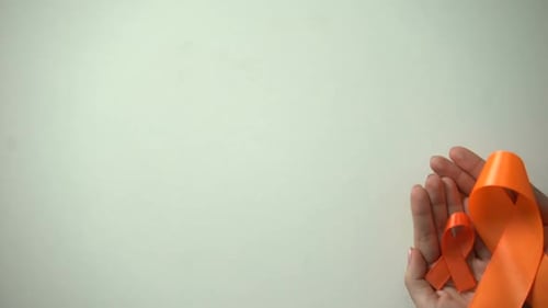 Hands Holding Orange Awareness Ribbons