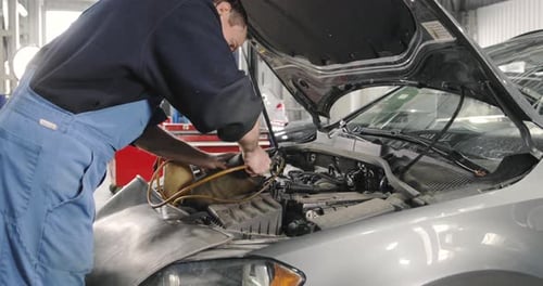 Mechanic Working on Engine in Auto Repair Shop