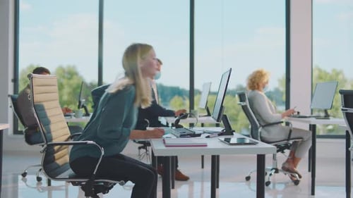 Workers Using Computers Wearing Face Masks in Office