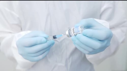 Crop doctor filling syringe with drug in hospital