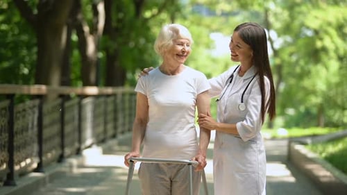 Smiling Senior Woman Walking with Healthcare Provider