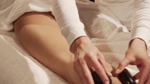 Young, healthy and beautiful woman gets massage therapy in the spa salon.