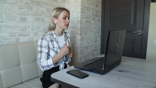 Woman Works Behind Laptop in Kitchen