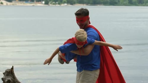 Dad and Son Play Superhero by Lake
