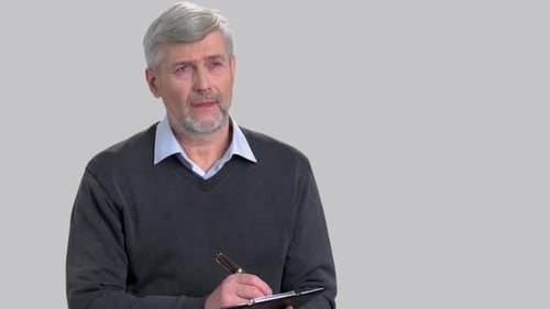 Man Writing on Clipboard in Studio Setting