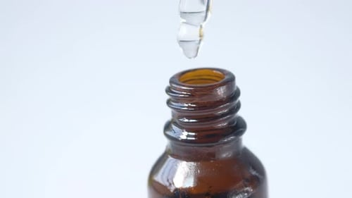 Drop Falls From a Pipette Into a Cosmetic Bottle