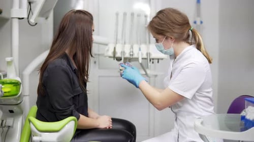 Friendly Dentist Explains Procedure to Patient in Office
