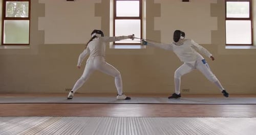 Fencer athletes during a fencing training in a gym
