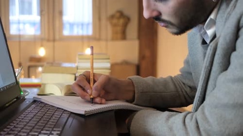 Young Adult Writing Notes at Desk Indoors