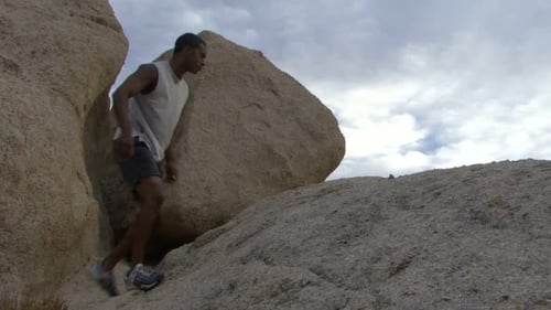 Man Climbing Up Rocky Hill Outdoors