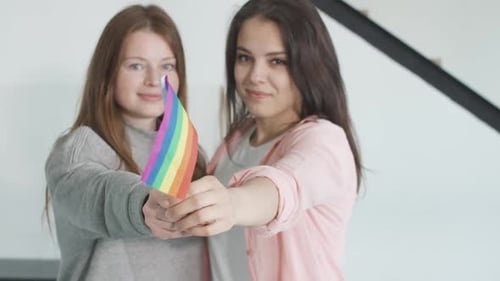 Two Young Adults Holding Pride Flag