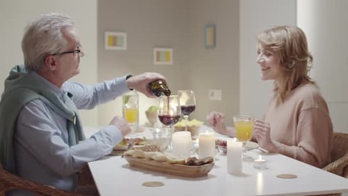 Couple Toasts With Wine Over Candlelit Dinner