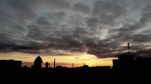 Aerial view of a drone flying over the city. Sunset in the sky.