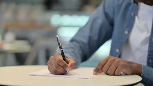 African Man Writing on Paper Close Up