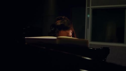 Woman Plays Piano in Music Studio at Night