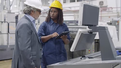 African American Female Factory Engineer Showing Machinery Work
