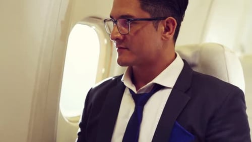 Business Man Working on Laptop in Airplane