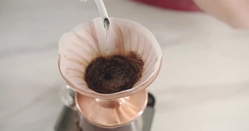 Pouring Water Over Coffee Grounds in Filter