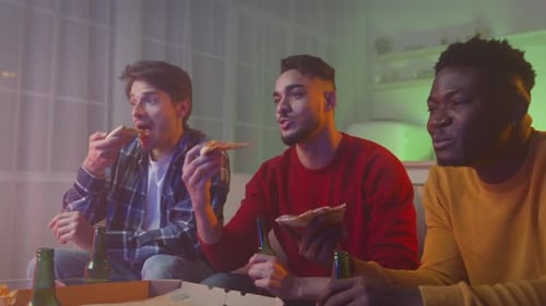 Three Friends Enjoying Pizza and Beers at Home