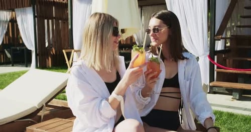 Two Women in Sexy Swimwear are Relaxing Near Pool