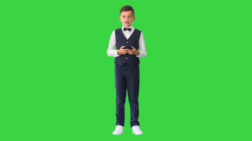 Little Boy in a Bow Tie and Waistcoat Talking To the Camera on a Green Screen Chroma Key