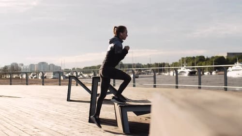 Fit Woman Steps on Bench in Park
