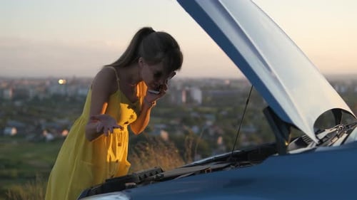 Stressed Woman Driver Talking on a Phone Standing Near Her Vehicle with Popped Hood Having Engine