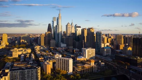 Aerial timelapse rotating view of the Philadelphia skyline during a warm sunset showcasing the tall,
