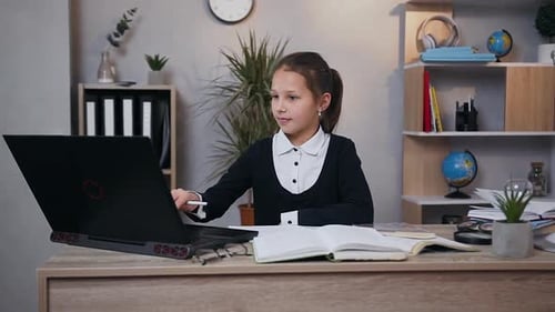 Girl Studies at Desk with Laptop and Notebook