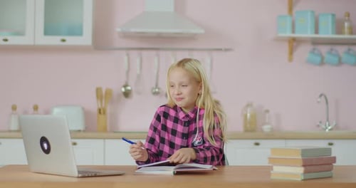 Girl Studies with Laptop in Kitchen