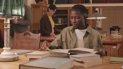 African American University Student Studying in Library