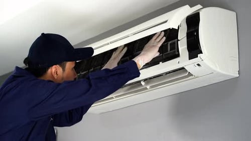 Man Installing Air Conditioner Cover in Home