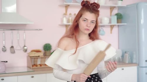 Red Haired Woman in Kitchen Holds Rolling Pin