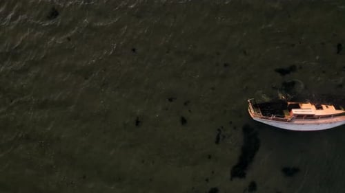 Aerial Panning Shot of Boat with Half It’s Body Immersed in Ocean Water