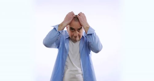 Man Pulls Hair in Frustration Against White Background