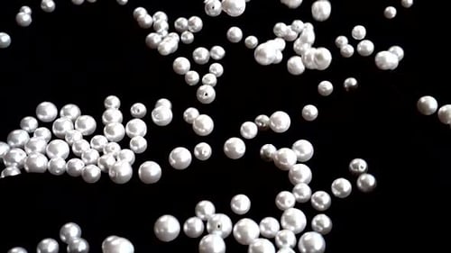 Luminous Pearls Falling on Black Background