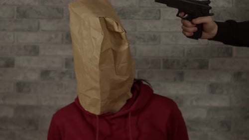 Person With Paper Bag on Head with Gun