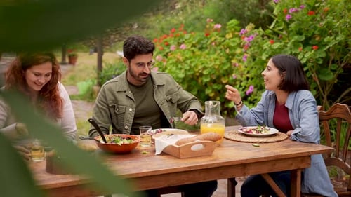 Friends Enjoying Outdoor Meal Together in Garden