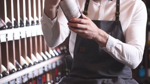 Young Adult Examining Wine Bottle in Wine Shop